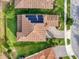 Aerial view of house with solar panels on the roof, driveway and grass yard at 4024 Woods Rider Loop, Odessa, FL 33556