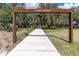 Inviting entrance to Albritton Park, featuring a paved pathway leading through lush greenery and mature trees at 4024 Woods Rider Loop, Odessa, FL 33556