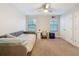Cozy bedroom with a ceiling fan, two windows for natural light, and neutral carpet at 4024 Woods Rider Loop, Odessa, FL 33556