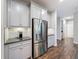 Close up view of kitchen featuring stainless steel refrigerator and granite countertop with a decorative backsplash at 4024 Woods Rider Loop, Odessa, FL 33556