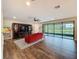 Bright living room featuring wood flooring, large windows offering scenic views, and a comfortable seating area at 4024 Woods Rider Loop, Odessa, FL 33556