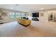 Spacious living room with a large television, a comfortable seating area, and multiple windows for natural light at 4024 Woods Rider Loop, Odessa, FL 33556