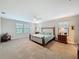 Large main bedroom features natural lighting, ceiling fan, and neutral colored carpet at 4024 Woods Rider Loop, Odessa, FL 33556