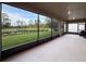 Enclosed patio with a scenic view of the manicured lawn and pond at 4024 Woods Rider Loop, Odessa, FL 33556