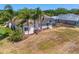 Aerial view showcasing the home's landscaped backyard, mature trees, and a screened-in lanai at 5113 Epping Ln, Zephyrhills, FL 33541