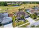 Scenic aerial view of home with lush landscaping, pool, golf course and community pond at 5113 Epping Ln, Zephyrhills, FL 33541