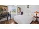 Inviting bedroom with wood floors, large window, and stylish furnishings including an upholstered bed and accent furniture at 5113 Epping Ln, Zephyrhills, FL 33541