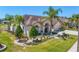 Beautiful home showcasing a well-maintained lawn, mature landscaping, and architectural details at 5113 Epping Ln, Zephyrhills, FL 33541