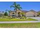 Charming home featuring well-manicured landscaping, a two-car garage, and a welcoming entrance at 5113 Epping Ln, Zephyrhills, FL 33541