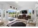 Bright living room with fireplace, large screen TV, and sliding glass doors at 5113 Epping Ln, Zephyrhills, FL 33541