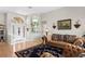 Inviting living room featuring hardwood floors, a comfortable couch, and elegant decor at 5113 Epping Ln, Zephyrhills, FL 33541