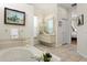 Bathroom with a soaking tub and tiled floor, as well as and sinks at 5113 Epping Ln, Zephyrhills, FL 33541