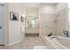 The bathroom features a soaking tub, shower, white cabinets, and a tiled floor at 5113 Epping Ln, Zephyrhills, FL 33541