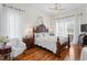 The bright main bedroom features a decorative wood bed frame, wood floors, and sheer curtains at 5113 Epping Ln, Zephyrhills, FL 33541