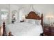 The bright bedroom features a decorative wood bed frame and luxurious bedding at 5113 Epping Ln, Zephyrhills, FL 33541