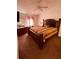 Comfortable bedroom features a large wooden bed frame, a ceiling fan, and neutral carpeted floors at 5407 Sweetwater Terrace Cir # 5407, Tampa, FL 33634