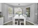 Bright dining area with large windows overlooking the pool, features a modern white table set at 5807 Cay Cove Ct, Tampa, FL 33615