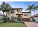 Charming two-story home with lush tropical landscaping, tile roof, and brick driveway at 5807 Cay Cove Ct, Tampa, FL 33615