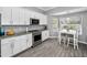 Well-lit kitchen features white cabinets, stainless appliances, and a dining area with a pool view at 5807 Cay Cove Ct, Tampa, FL 33615