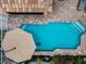 Overhead view of a sparkling pool with brick trim, umbrella and pool cleaner, providing a relaxing retreat at 5807 Cay Cove Ct, Tampa, FL 33615