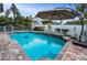 Inviting backyard pool with clear blue water, surrounded by lush landscaping and a sunshade at 5807 Cay Cove Ct, Tampa, FL 33615