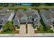 Aerial view of attached homes showing brick driveways, landscaping, and architectural roof lines at 597 Ozona Village Dr, Palm Harbor, FL 34683