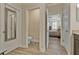 Bright bathroom showing a toilet room, wood floors, and a door to the primary bedroom at 597 Ozona Village Dr, Palm Harbor, FL 34683