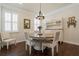 Elegant dining room with a round table, white chairs, and a stylish chandelier at 597 Ozona Village Dr, Palm Harbor, FL 34683