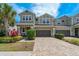 Charming two-story townhome with a well-manicured front yard and a paved driveway at 597 Ozona Village Dr, Palm Harbor, FL 34683