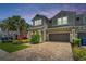 Charming townhome with a two-car garage, beautiful landscaping, and a brick paver driveway at 597 Ozona Village Dr, Palm Harbor, FL 34683