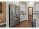 Kitchen area featuring a stainless steel refrigerator, granite countertops, and white cabinets at 597 Ozona Village Dr, Palm Harbor, FL 34683