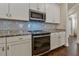 Kitchen showcases stainless steel appliances, granite countertops, and sleek white cabinetry at 597 Ozona Village Dr, Palm Harbor, FL 34683