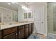 Spacious main bathroom with a double vanity, wood cabinets, and glass-enclosed shower at 597 Ozona Village Dr, Palm Harbor, FL 34683