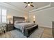 Serene main bedroom with tray ceiling, a king bed, and a sitting bench at 597 Ozona Village Dr, Palm Harbor, FL 34683