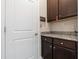 Convenient mud room with dark wood cabinets, granite counters, and functional storage at 597 Ozona Village Dr, Palm Harbor, FL 34683