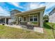 Relaxing covered patio with outdoor seating, string lights, and a fan at 597 Ozona Village Dr, Palm Harbor, FL 34683