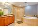 Well-lit bathroom featuring a glass shower, soaking tub, and double vanity at 600 Bayway Blvd # 304, Clearwater, FL 33767
