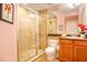 Bright bathroom featuring a glass-enclosed shower and a vanity with granite countertop at 600 Bayway Blvd # 304, Clearwater, FL 33767