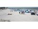 Wide sandy beach featuring tents, umbrellas, and people enjoying the sunshine at 600 Bayway Blvd # 304, Clearwater, FL 33767