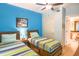 Charming bedroom with two twin beds, blue accent wall, and ensuite bathroom access at 600 Bayway Blvd # 304, Clearwater, FL 33767