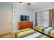 Comfortable bedroom featuring twin beds, dresser, and large window for natural light at 600 Bayway Blvd # 304, Clearwater, FL 33767