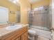 Bathroom featuring tile countertops and a shower-tub combination with sliding glass doors at 6018 Gannetdale Dr, Lithia, FL 33547