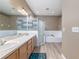 Bright bathroom features a dual sink vanity, glass shower, and soaking tub for a spa-like experience at 6018 Gannetdale Dr, Lithia, FL 33547