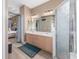 Bathroom featuring dual sinks, wood-look tile floors, and glass shower, adjacent to a bedroom at 6018 Gannetdale Dr, Lithia, FL 33547