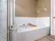 Bathroom features an inviting white tiled soaking tub with caddy, next to glass shower at 6018 Gannetdale Dr, Lithia, FL 33547