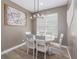 Cozy dining area featuring a white dining set illuminated by a modern chandelier and natural light at 6018 Gannetdale Dr, Lithia, FL 33547