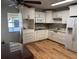 Modern kitchen boasts white cabinets, stainless steel appliances, and wood-look floors at 6047 67Th N Ave, Pinellas Park, FL 33781