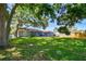 Expansive backyard with lush green grass, mature trees, and a patio perfect for outdoor entertaining at 6207 Gulfport S Blvd, Gulfport, FL 33707