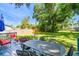Landscaped backyard featuring a deck with table, chairs, and a fire pit at 6207 Gulfport S Blvd, Gulfport, FL 33707