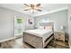 Bedroom showcasing a modern bed frame, ceiling fan, and wood laminate flooring at 6207 Gulfport S Blvd, Gulfport, FL 33707
